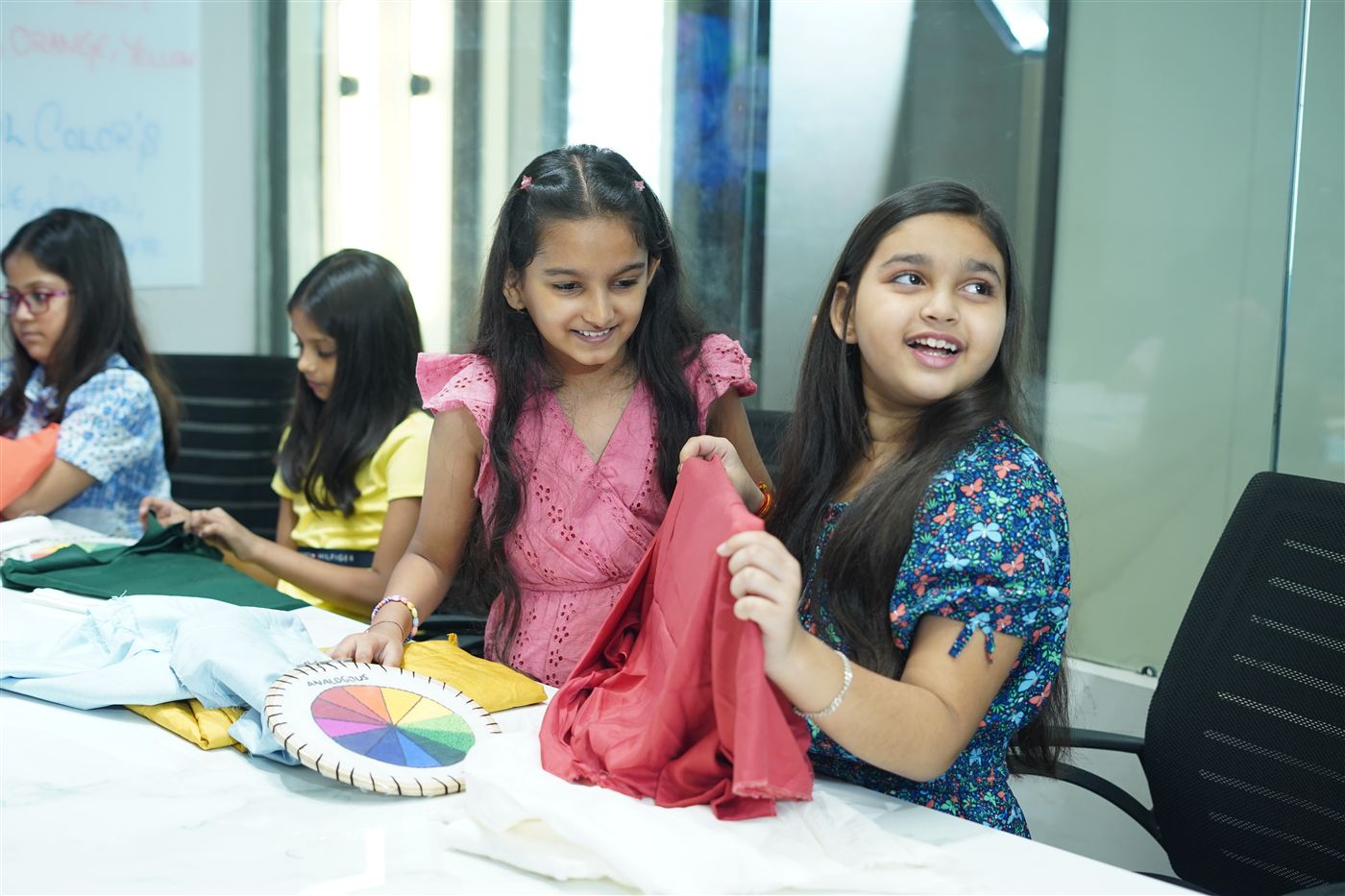 Girls exploring fabrics with a colour wheel