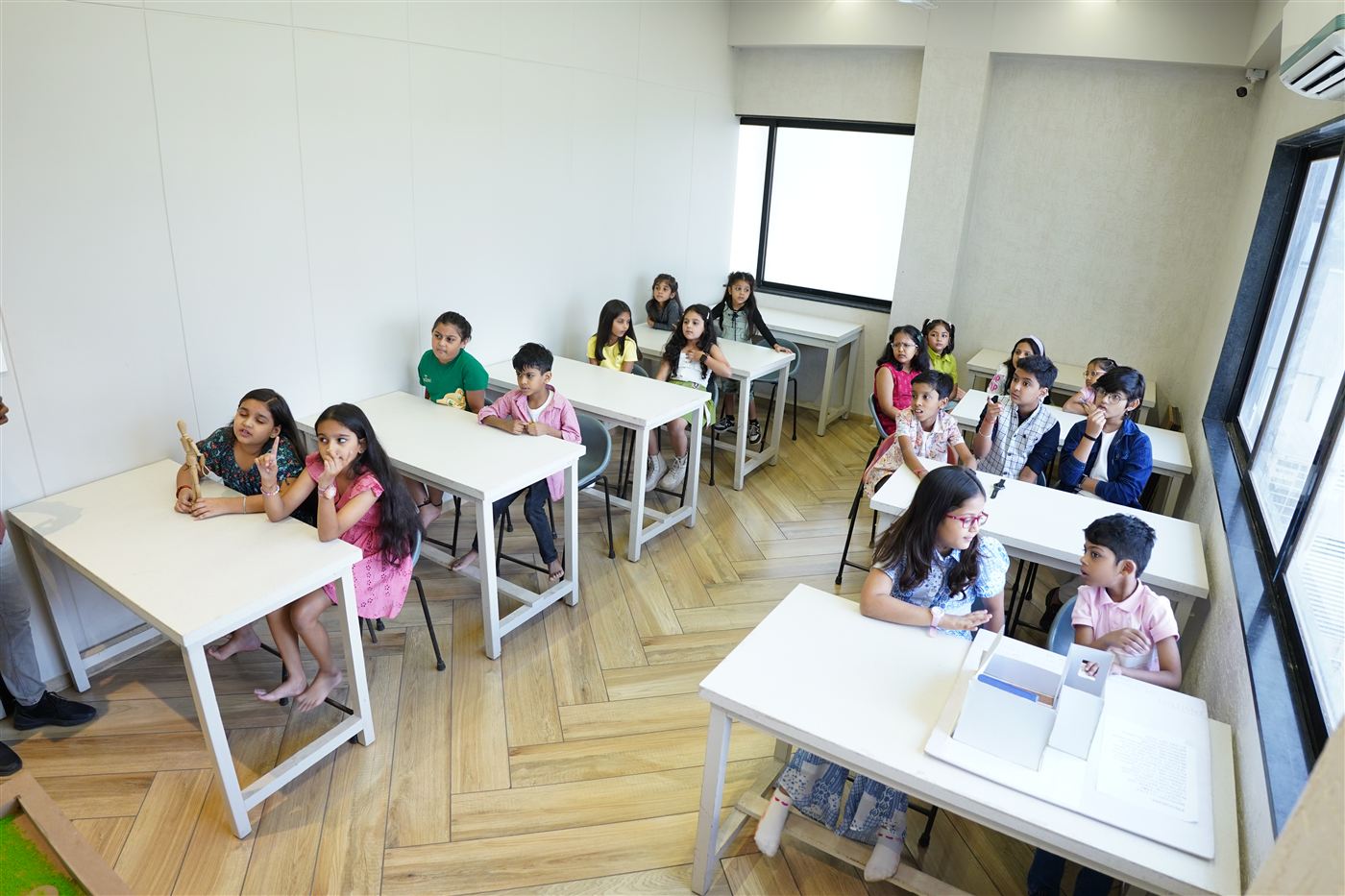 Kids seated in a bright, airy classroom